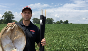 Man holding a sweep net and a drop cloth