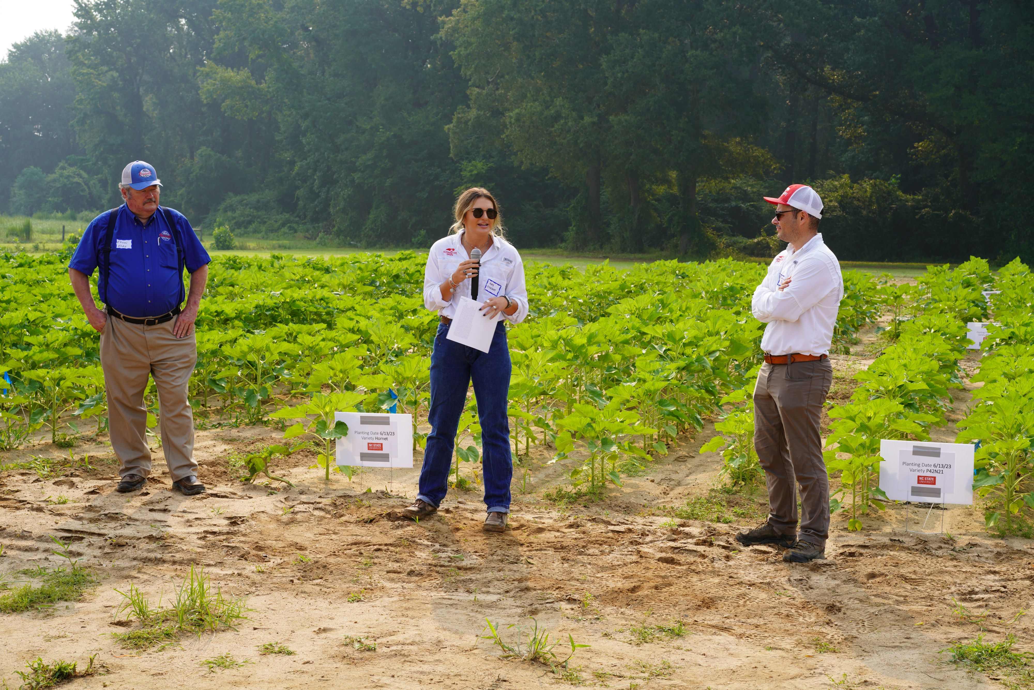 A woman gives a talk in a field.