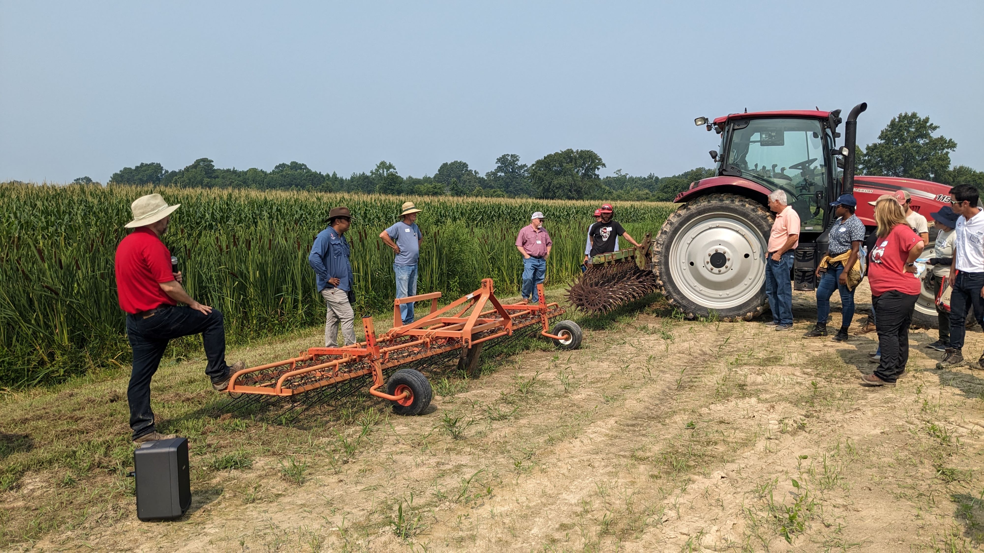 A group of farmers inspect equipment.